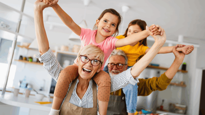 A senior couple playing with their two grand-daughters